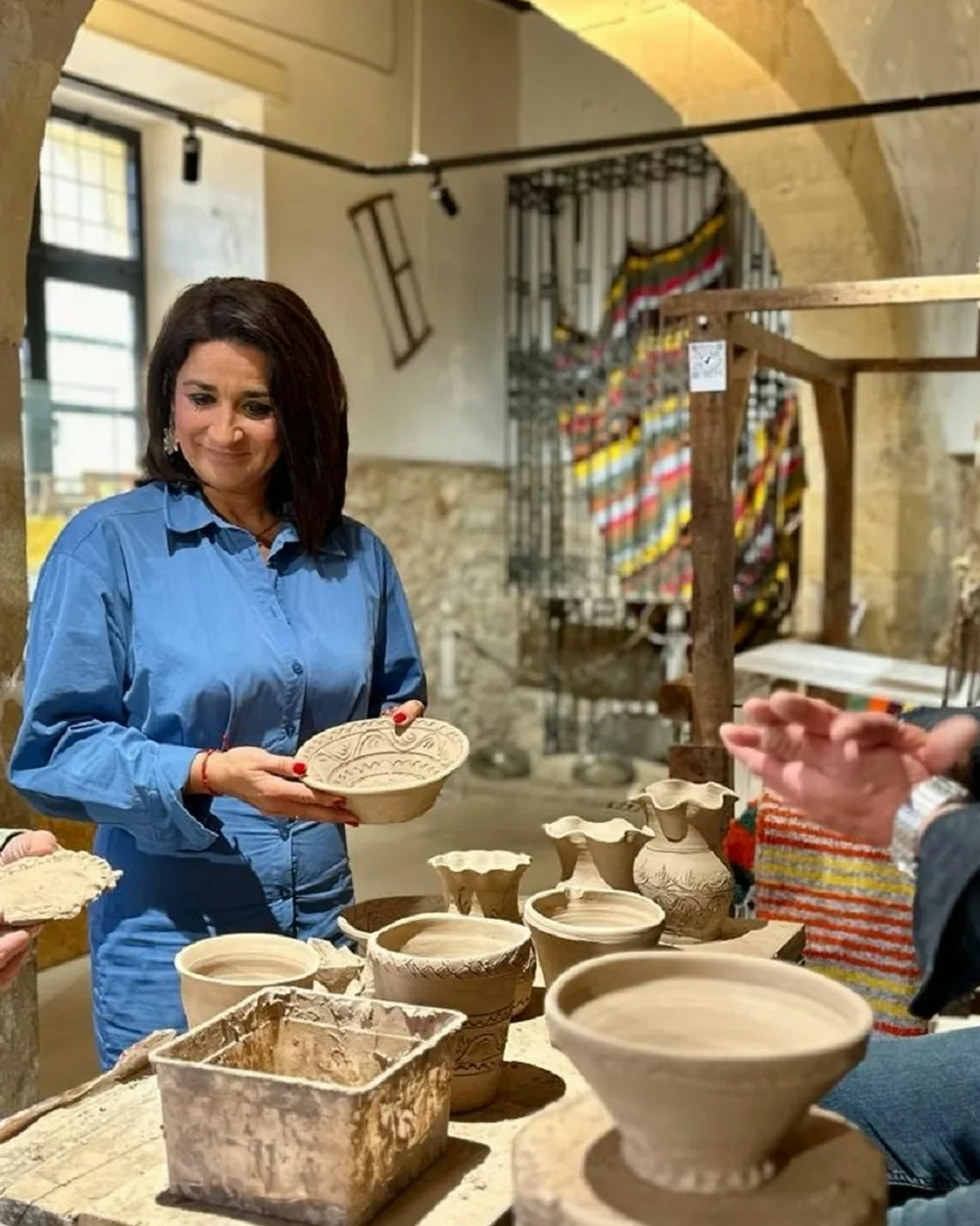 Clienta con un plato de cerámica pintado a mano en la tienda de la alfarería